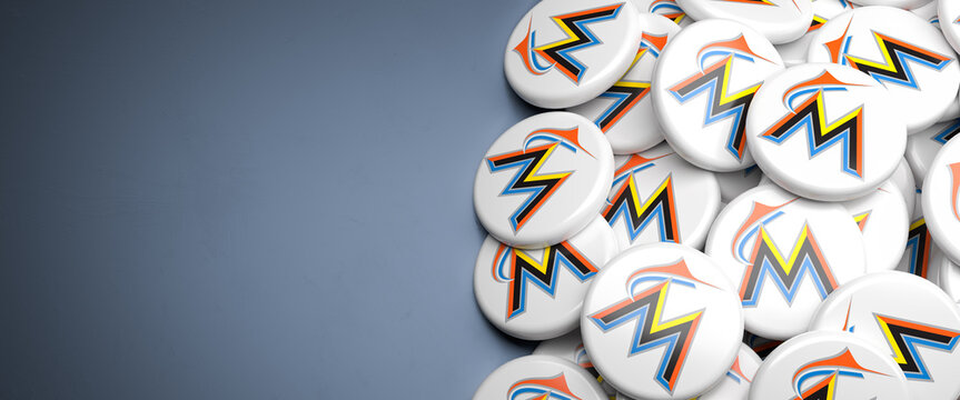 Logos of the American Major League Baseball Team Miami Marlins on a heap on a table.
