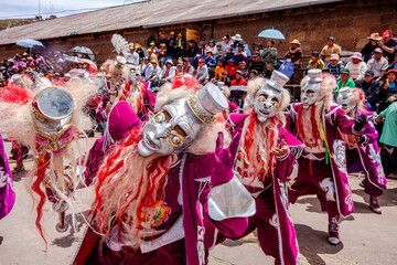Dancers with typical devil costumes and other representations celebrate the festival of the Virgen...