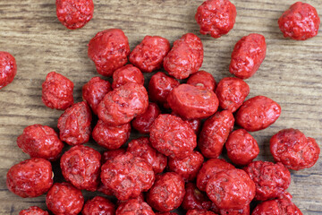 Red sugar coated peanuts in wooden background 