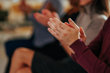 Closeup of hand clapping in meeting.