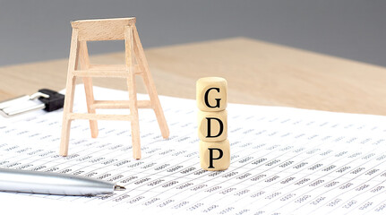 wooden cubes with the word GDP stand on a financial background, business concept.