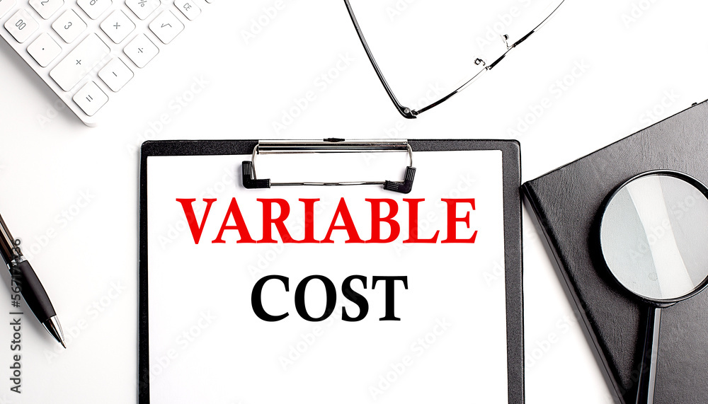 Poster variable cost text written on paper clipboard with office tools