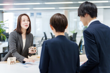 不動産の模型を使って打ち合わせをする人々