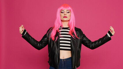 Carefree happy woman feeling zen and meditating in studio, working on mindfulness and healthy body. Stylish cool person feeling in harmony and doing yoga pose to meditate on camera.
