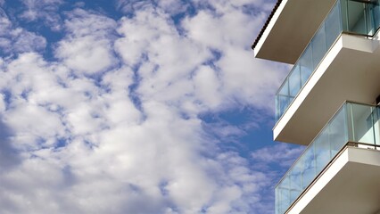 building with glass railings against the cloudy sky