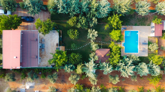 Title: blue swimming pool. The pool with people swimming in it, taken from the hill. people swimming in the pool
