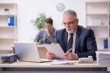 Obraz premium Two male employees working in the office