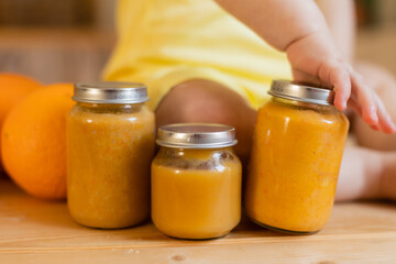 baby vegetable and fruit puree in jars in the kitchen, mockup. Baby food, space for text. Jars of baby food on a wooden table