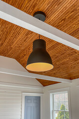 Black and Brass Hanging Light on Wood Ceiling with Beams