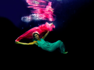 Fototapeta na wymiar Model underwater with long dress and chiffon in pool