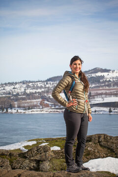 Portrait of young woman posing against river and snowy hill, Bingen, Washington, USA
