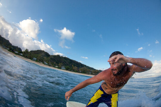 Jon Boulware surfing during sunrise at Monster Mush, on the north shore of Oahu, Hawaii