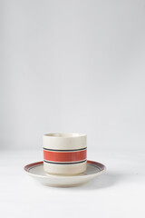 Cream and red ceramic cup on a saucer, Cream and red teacup
