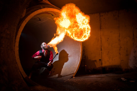 Fire breather blows flame in tunnel.