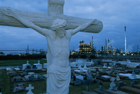 Statue of Jesus and raised graves in a cemetery in Taft, Louisiana.