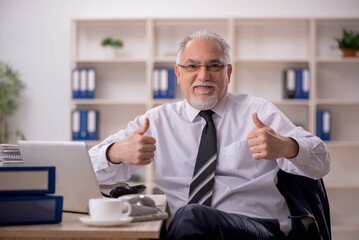 Old male employee working in the office