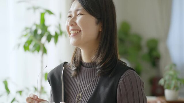 眼鏡を外す笑顔の女性
