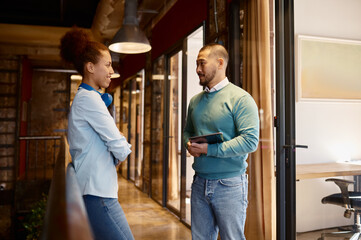 Fototapeta premium Diverse colleagues talking in hallway of modern coworking office