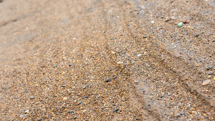 Fototapeta na wymiar River sand texture with a mixture of iron ore and pebbles