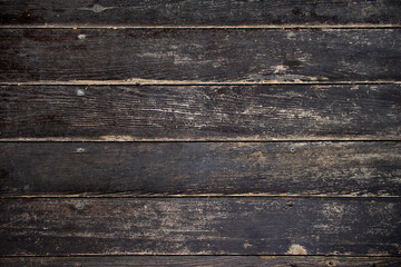 texture of a weathered and worn dark wooden surface of an old table top or parquet floor - textured medieval background for a wallpaper or a banner of a traditional rustic product