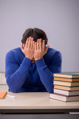 Young male student preparing for exams in the classroom
