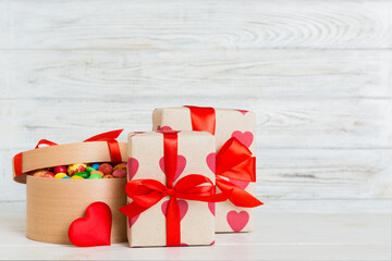 Valentine day composition: sweet candy, with gift boxes with bow and red felt hearts, photo...