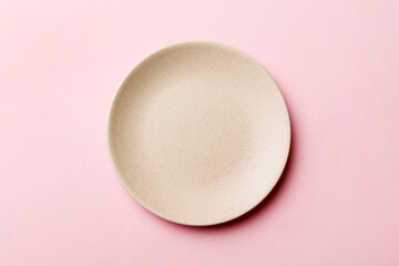 Top view of isolated of colored background empty round beige plate for food. Empty dish with space for your design