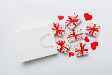 Gift boxes pop out from paper bag top view on colored background. bag packing handmade boxes fall out Concept of holidays, shopping, sale, discounts. Top view, flat lay