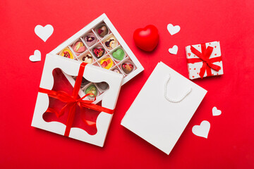 Valentine day composition: sweet candy, with gift boxes with bow and red felt hearts, photo...
