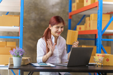 Attractive asia woman warehouse stock checking product stock on shelf.