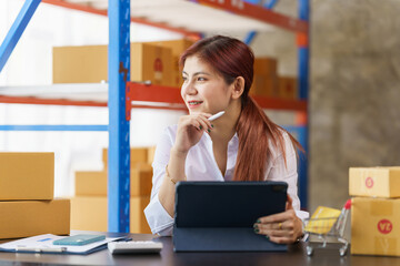 Attractive asia woman warehouse stock checking product stock on shelf.