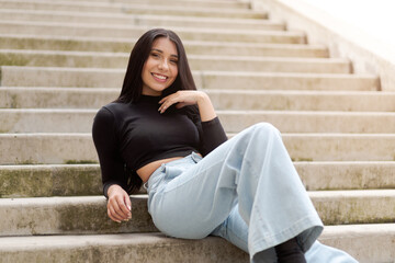Beautiful smile of latina woman sitting on a concrete stairway