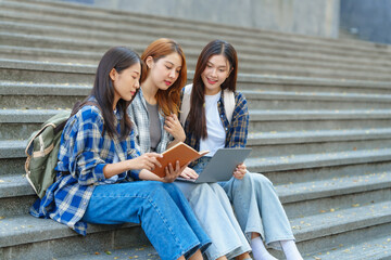 Attractive asian college student using laptop and tablet studying with group of friends together with english language classroom, social media and education concept.