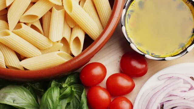 Colorful pattern of italian pasta, tomatoes, sauce, penne pasta ingredients, olive oil spices and basil, Top view Food concept.