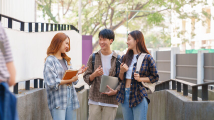 Attractive asian college student using laptop and tablet studying with group of friends together with english language classroom, social media and education concept.