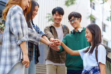 Attractive asian college student using laptop and tablet studying with group of friends together with english language classroom, social media and education concept.