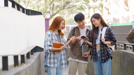 Attractive asian college student using laptop and tablet studying with group of friends together with english language classroom, social media and education concept.