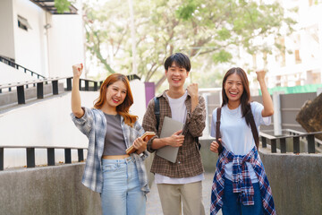 Attractive asian college student using laptop and tablet studying with group of friends together with english language classroom, social media and education concept.