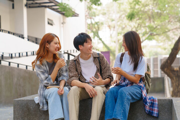 Attractive asian college student using laptop and tablet studying with group of friends together with english language classroom, social media and education concept.