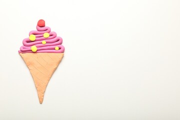 Ice cream cone made of plasticine on white background, top view