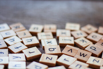 English alphabet made of square wooden tiles with the English alphabet scattered on table. The...