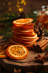 Dry orange slices, anise stars and cinnamon sticks on wooden board. Bokeh effect
