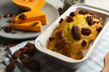 Delicious pumpkin bread with pecan nuts on light wooden table