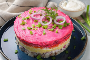 Herring under fur coat salad on light grey table, closeup. Traditional Russian dish