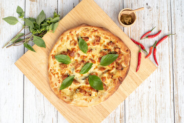 Spicy pizza on a wood cutting board with ingredients