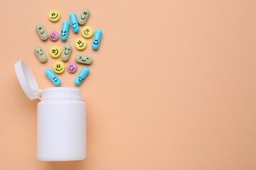 Bottle and antidepressant pills with funny faces on pale orange background, flat lay. Space for text