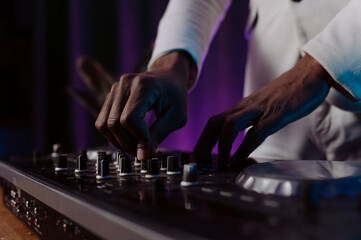 hands control the remote control. setting the remote control knob. electronic device of the mixer console.