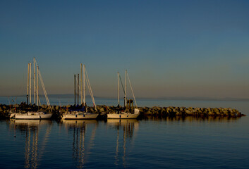 Fototapeta na wymiar Three sailboats at golden hour with plenty of copy space.