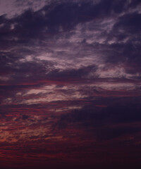 Clouds in the sky at sunrise in warm red tones. Purple clouds sunset at early evening. 