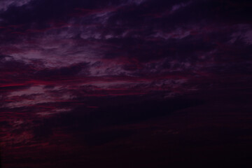 Cloudscape in the sky at sunrise in warm red tones. Purple clouds sunset at early evening. Abstract texture